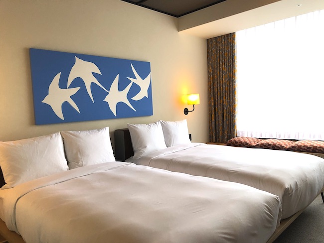 ベッドの上に飾られているのは、９０代の現役染色アーティスト・柚木沙弥郎の作品。
