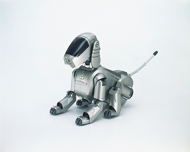 ソニー「AIBO ERS-110」 1999年（デザイン：空山基）　「AIBO」の1号機は、妖艶なメタリックイラストで知られるイラストレーター空山基のデザインを忠実に立体化したもの。なお、ロボット漫画の原型ともいえる『鉄腕アトム』の誕生は2003年の設定。「21世紀までにロボットを！」という未来への意志が、この画期的なエンターテインメントロボットを20世紀最後の年に誕生させたのかも。 © ソニーグループ株式会社