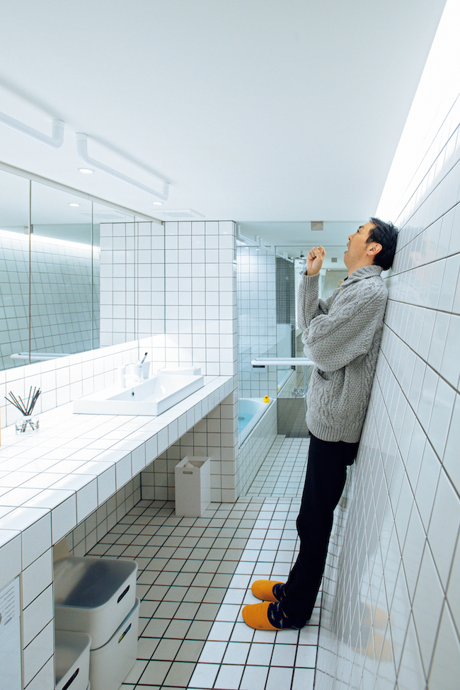 床と壁が白いタイルで包まれた洗面＆浴室。「寄りかかるとすごくラク!」と田中さん。寺田家では家族全員、歯を磨くときはこのスタイルだそう