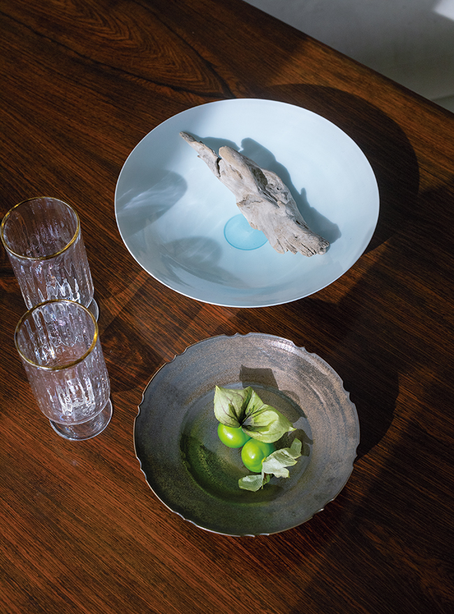 中里博恒さんの青白磁の平皿と磁器の小皿と田井将博さんのカフェオレグラス。「IROHA NYCで、初期からご紹介させていただいている作家さんの器は、実生活でも使っています。生活を彩る大切なもの」