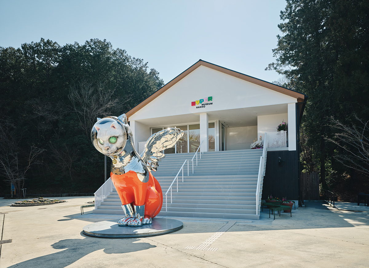 ハイパーミュージアム飯能と、その前に立つ『SHIP’S CAT (Ultra Muse / Red)』。　Photo：Takashi Kawashima