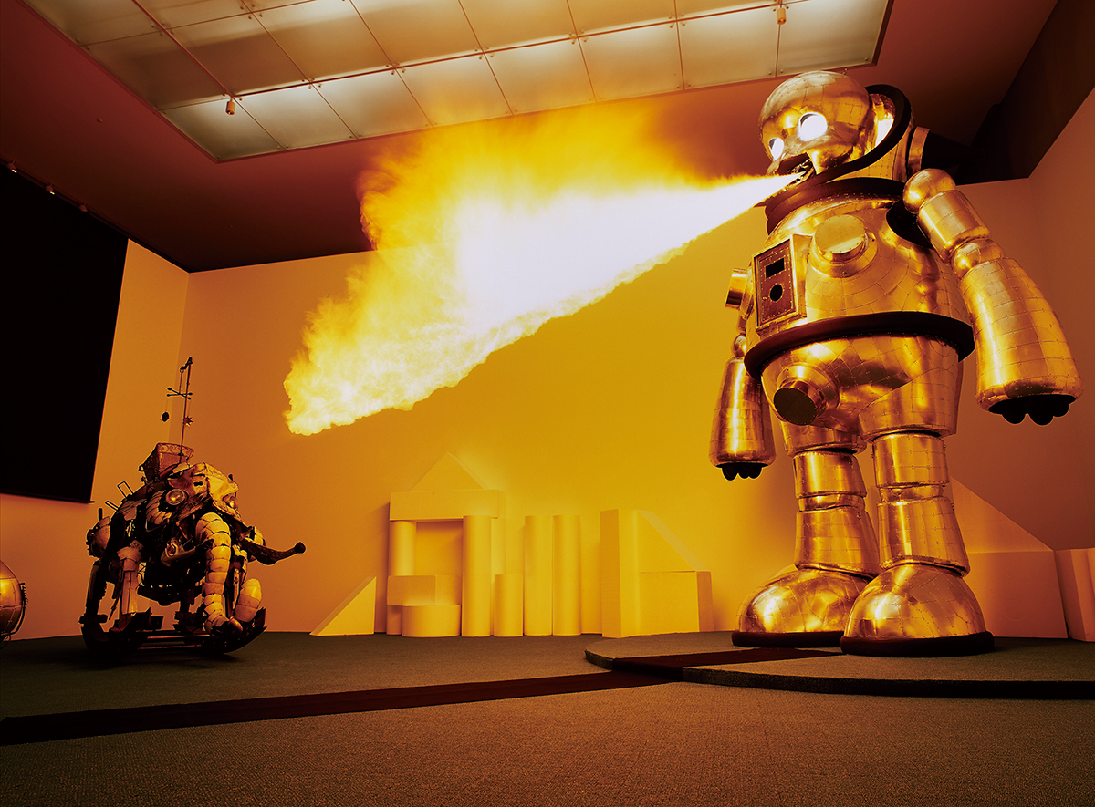 子どもの命令に従い火を噴くロボット『ジャイアント・トらやん』（右）と『ロッキング・マンモス』（左）（2005年）豊田市美術館の個展「KINDERGARTEN」でのパフォーマンス風景。　Photo：Seiji Toyonaga