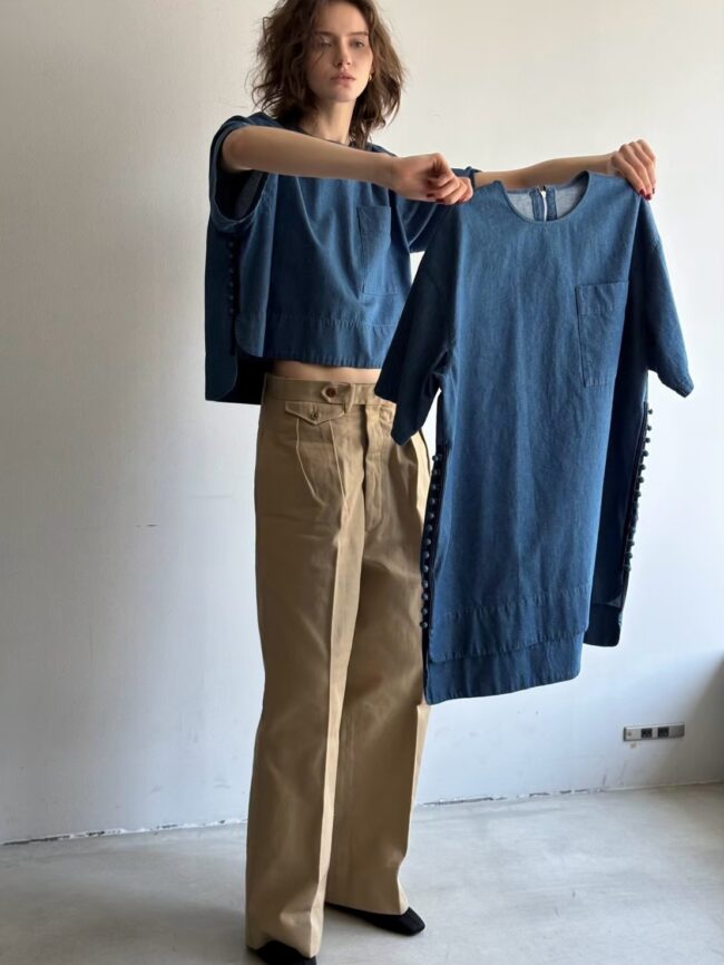 着用しているのが、Airyサイズ T blouse short denim。手に持っているのがFoundationサイズのT blouse denim