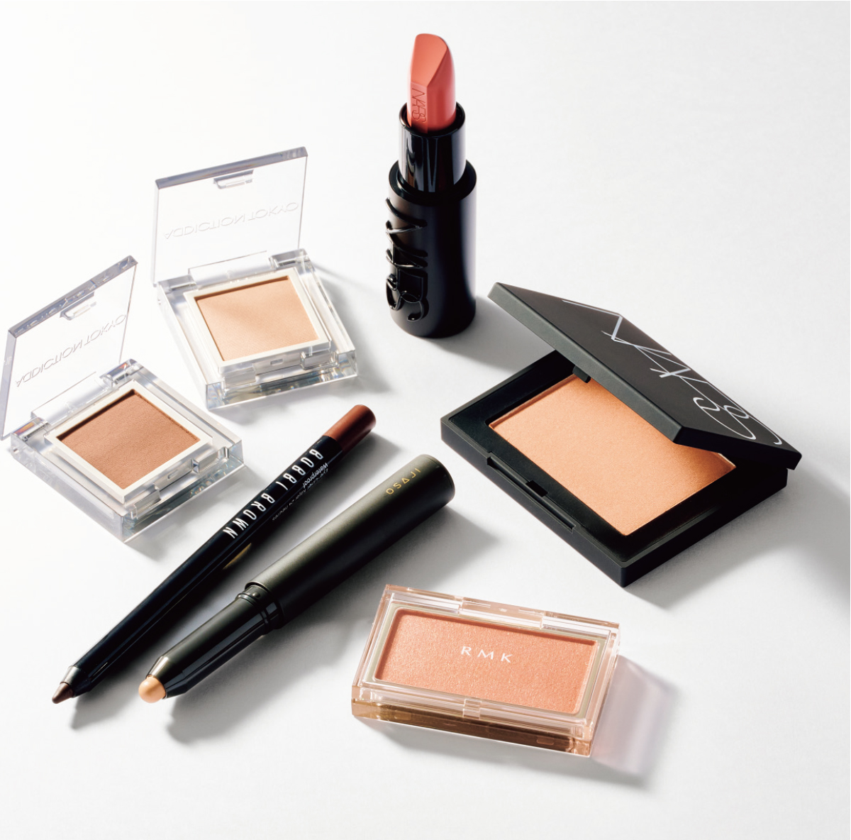  上中央から時計回りに：「ヌードピンクの血色感が気分」。エクスプリシット リップスティック 828 ￥5,280　「スキントーンのチークで陰影を」。ブラッシュN 957 ￥5,060／ともにNars（ナーズ ジャパン）　ピュア コンプレクション ブラッシュ EX-05 ￥3,630（限定発売）／RMK（RMK Division）　「“線”を整えると印象が締まります」。ニュアンス リップボーダー ライナー 00 ￥3,300／Osaji（オサジ）　カジャル ライナー ウォータープルーフ 08 ￥3,960／Bobbi Brown（ボビイ ブラウン）　「ミュート色はまぶたの陰影づくりに」。ザ シングル アイシャドウ マット 015M、004M 各￥2,530／Addiction（アディクション）