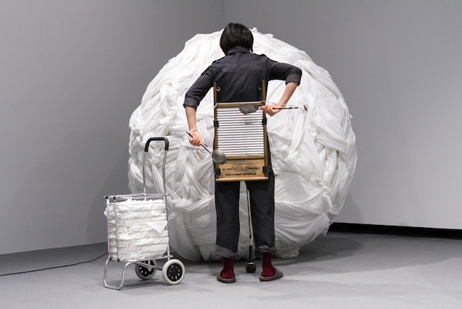 笹本晃『Delicate Cycle』(2016年) 第9回恵比寿映像祭「マルチプルな未来」2017でのパフォーマンス風景 撮影:新井孝明 図版提供:東京都写真美術館 ©︎Aki Sasamoto. Courtesy of Take Ninagawa, Tokyo