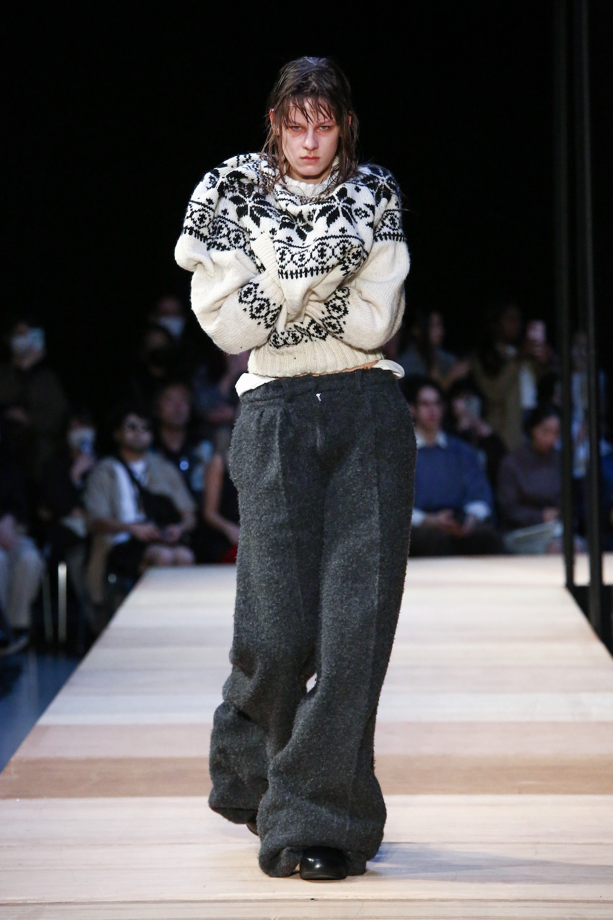 2023年秋冬コレクションより。ニットのフロントにはポッケがあしらわれ、モデルは自分を抱きしめるように歩いた