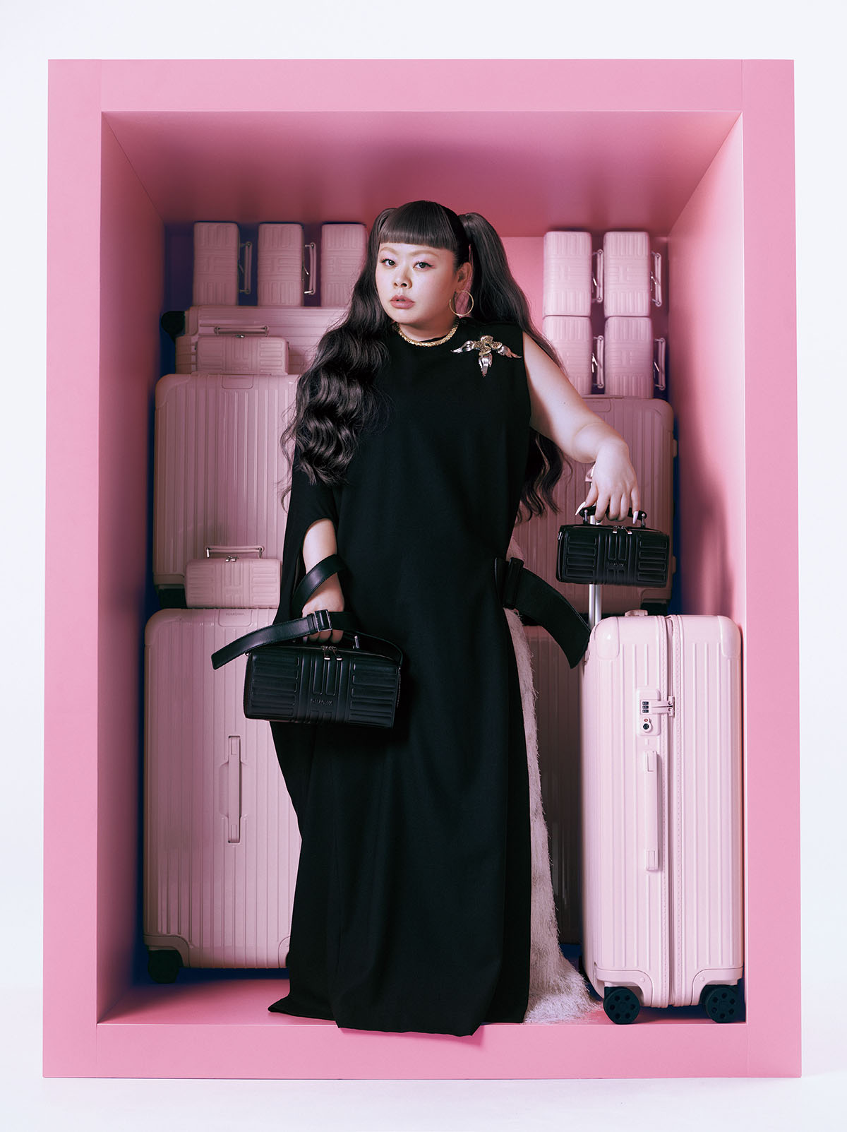 右手バッグ『Groove』クロスボディバッグ ラージ(W28×H13×D10cm)¥266,200 左手バッグ『Groove』クロスボディバッグ スモール(W19.5×H10×D8.5cm/取り外し可能なストラップ付き)¥180,400 左手スーツケース『Essential』チェックインL(W51×H77.5×D26.5cm/4.8kg・85L)¥179,300 ピンクのバッグ(奥)『Groove』クロスボディバッグ スモール(W19.5×H10×D8.5cm/取り外し可能なストラップ付き)各¥180,400 スーツケース『Essential』キャビン(W39×H55×D23cm/3.2kg・36L)各¥143,000 スーツケース『Essential』トランク プラス(W41×H80×D37cm/5.4kg・101L)¥226,600/すべてRimowa(リモワ クライアントサービス) ドレス¥128,000 スカート¥94,000 ブローチ¥66,000/すべてToga(トーガ 原宿店)フープイヤリング(PG)¥973,500 ネックレス(PG×ダイヤモンド)¥9,922,000/ともにChaumet(ショーメ)