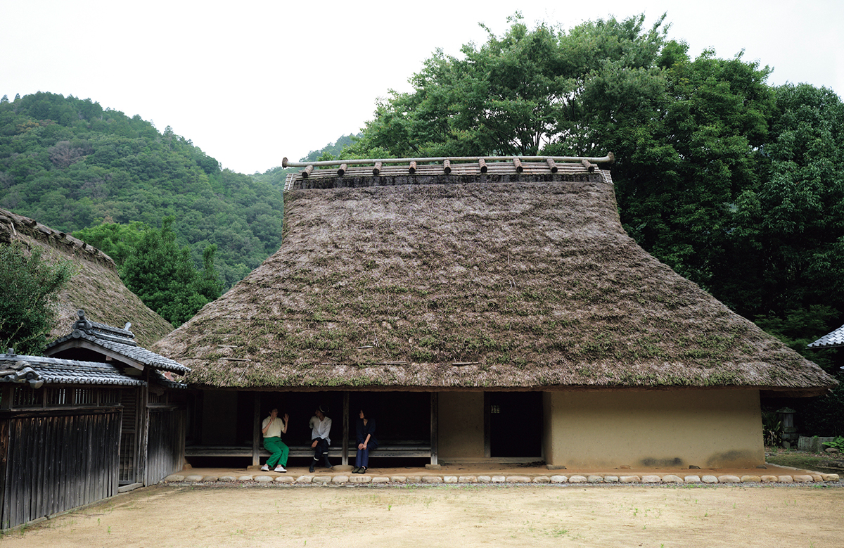 兵庫県に現存する日本最古の民家。縁側にて茅葺き職人と語らう。Photo：福田喜一　展覧会シリーズ「Life is beautiful：衣・食植・住」をめぐる探求の旅より。