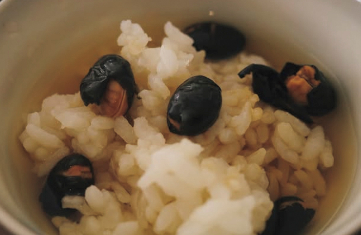 ご飯に煎り黒豆をのせ、ほうじ茶を注いだ「黒豆のチュン」。Instagram @eatripjournalより。