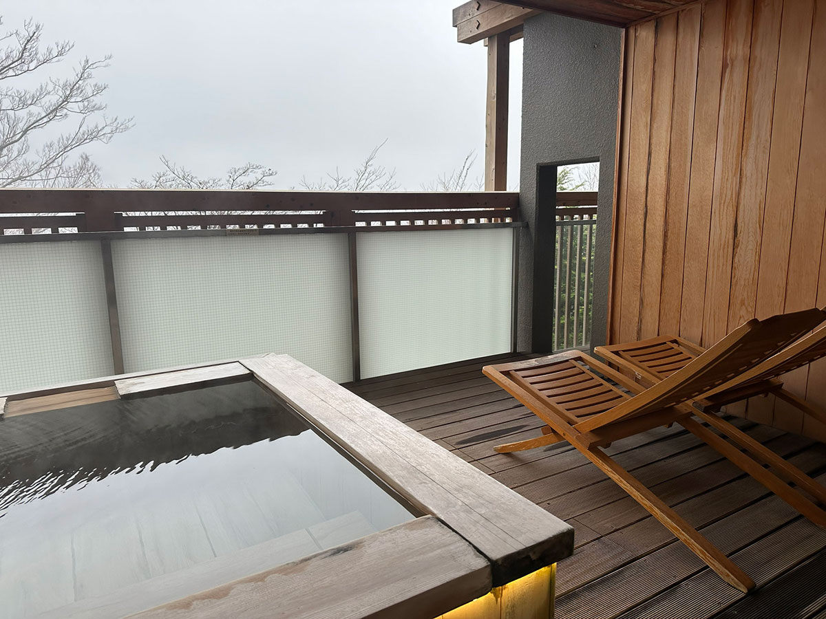 箱根連山を眺めながら湯浴みが楽しめる客室の露天風呂。その横にデッキチェアが配されている。温かい季節はここで寛ぐのも良さそう!