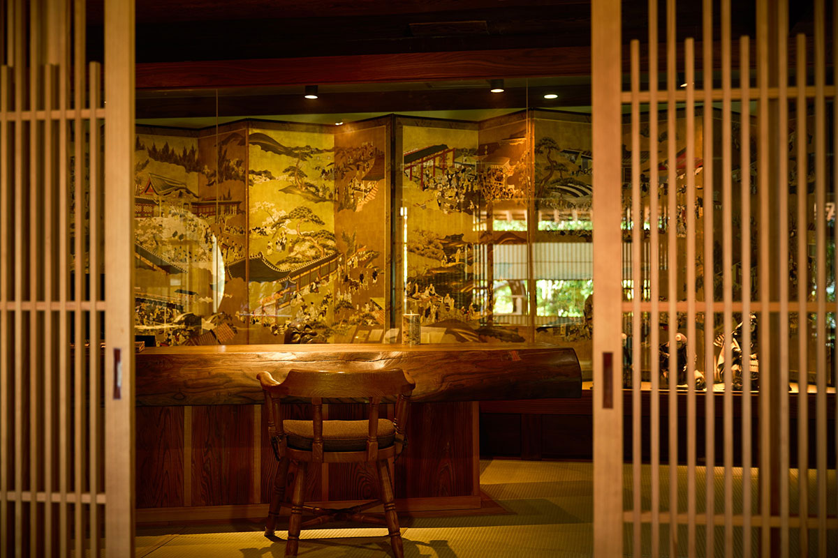 チェックインカウンターには神代欅の一枚板を使用。その後ろには金屏風が!