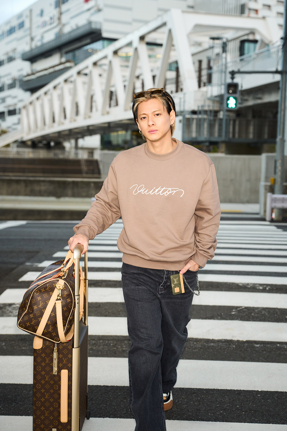 トップ ¥178,200 パンツ ¥192,500 スニーカー ¥169,400 サングラス¥81,400 チェーンベルト¥148,500 ピアス（単品） ¥51,700、リング ¥61,600、ウォッチ｢タンブール オトマティック スティール ブルー｣ ¥3,179,000、バッグ｢キーポル·バンドリエール 45｣ ¥414,700 スーツケース｢ホライゾン 55｣ ¥507,100 ウォレット｢ポルトフォイユ·ブラザ｣ ¥105,600