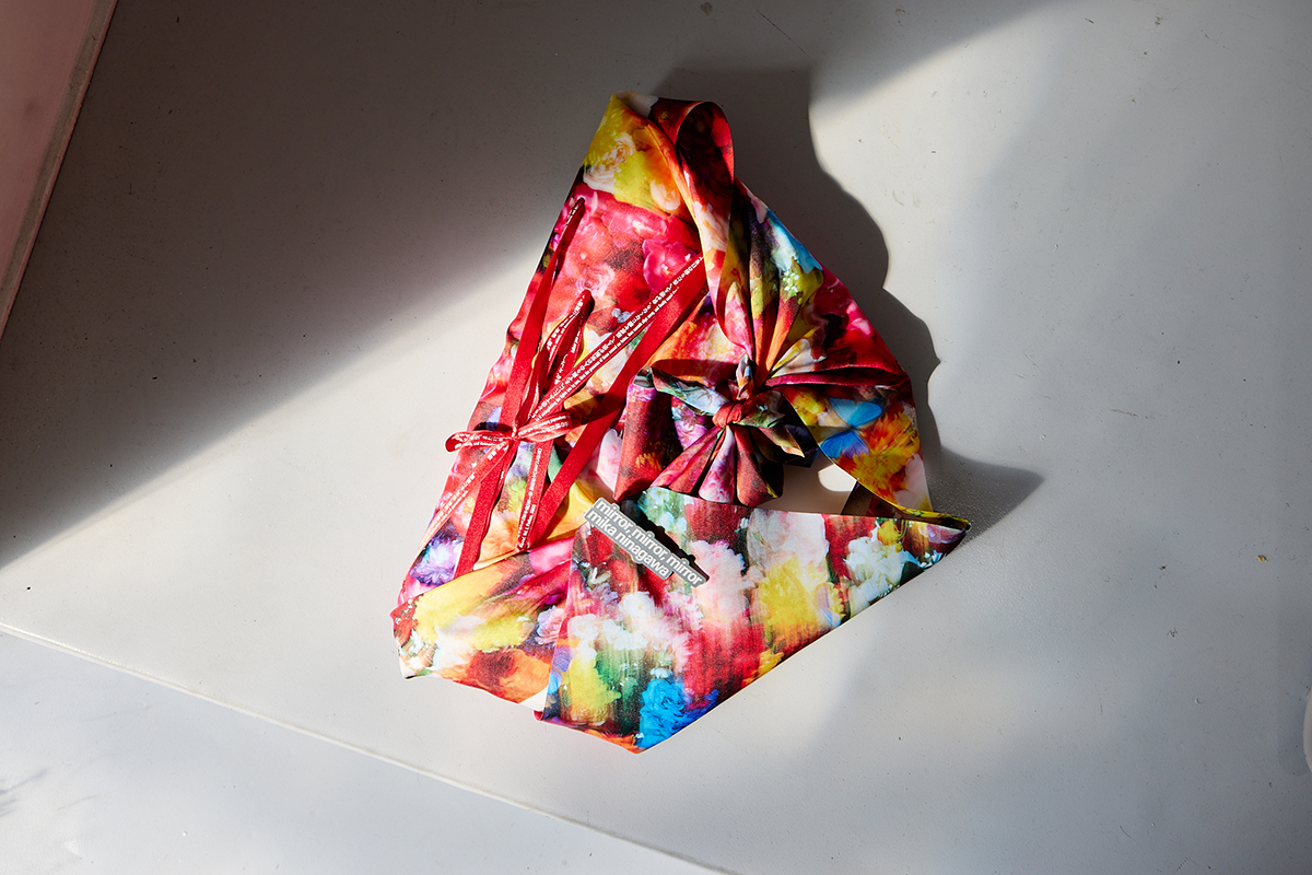 アーティストブック『mirror, mirror, mirror, mika ninagawa』のパッケージ。写真集などを風呂式状の“表紙”に包み込み、一つひとつリボンとバッジで留めてある。