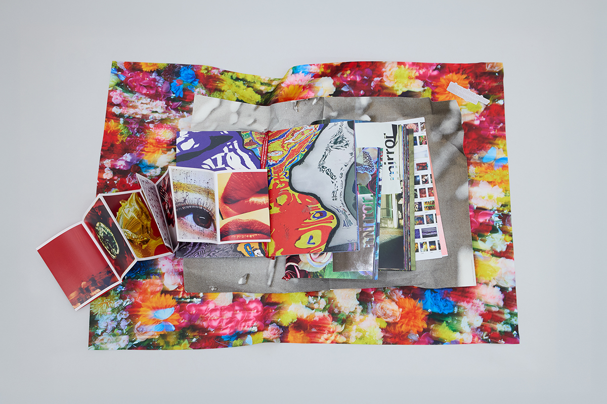 アーティストブック『mirror, mirror, mirror, mika ninagawa』より。大小さまざまな七つの冊子、ポスター、ステッカー、ポストカードなどが収められている。