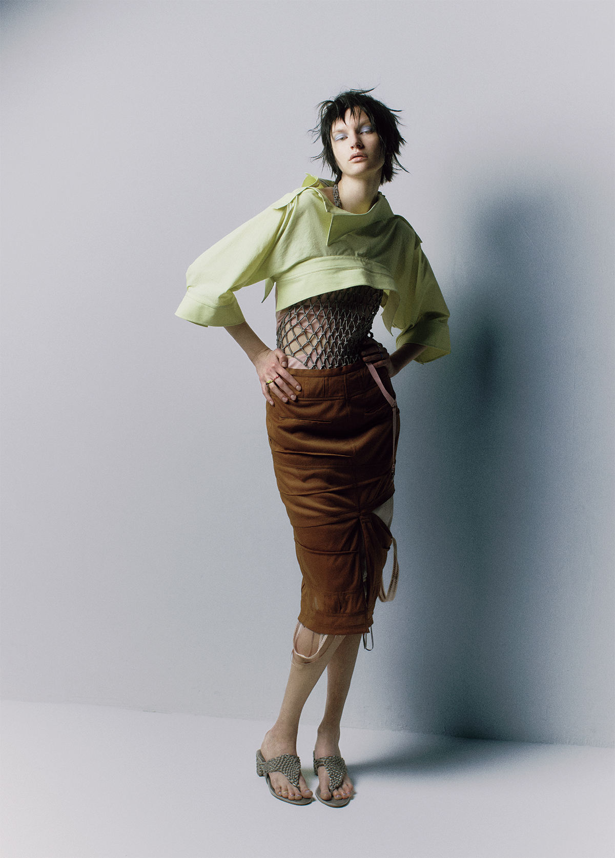 シャツ¥55,000／Issey Miyake（イッセイ ミヤケ）　ネットボディスーツ¥62,700　サンダル¥88,000／ともにIsa Boulder（バウ インク）　ガーターベルト付きビスチェ¥29,700　スカート¥39,600／ともにMukcyen（サカス ピーアール）　中にレイヤードしたスカート¥ 82,500／Keisukeyoshida（ケイスケヨシダ カンパニー・リミテッド）　リング〈左手中指〉￥112,060 〈左手薬指〉￥88,870〈右手中指〉￥88,870 〈右手薬指〉￥112,060（すべて参考価格）／Bea Bongiasca（ベア ボンジャスカ カスタマーケア）