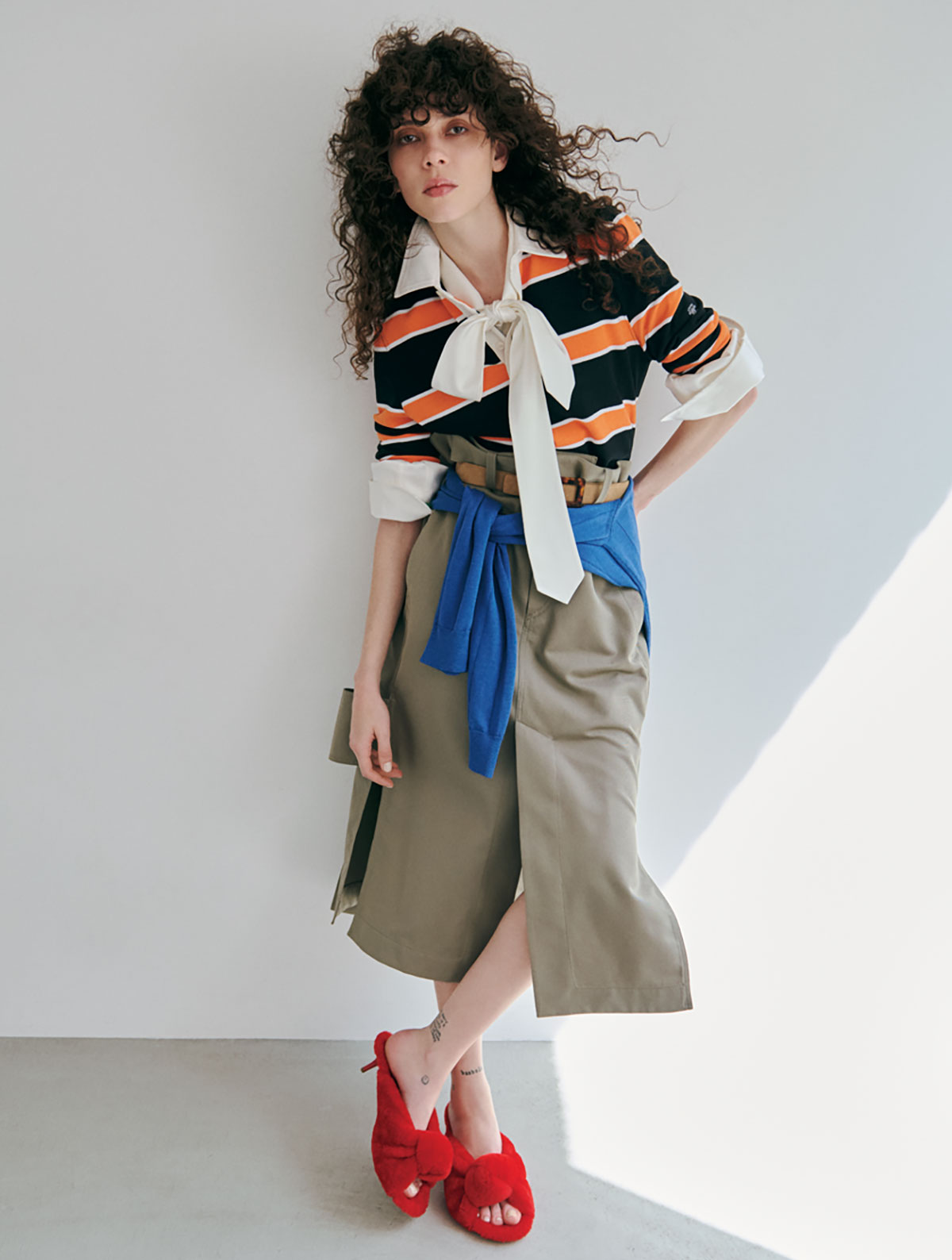 ポロシャツ¥170,500　腰に巻いたポロシャツ¥214,500（ともに予定価格／メンズ）／Celine（セリーヌ ジャパン）　中に着たブラウス¥479,600　スカート¥359,700　シューズ¥242,000／すべてBottega Veneta（ボッテガ・ヴェネタ ジャパン）　ベルト¥86,900／Roger Vivier（ロジェ・ヴィヴィエ・ジャパン）