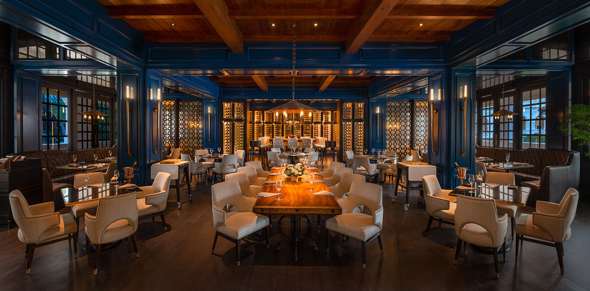 ライブラリー風のワインセラーを備え、コバルトブルーとダークウッドが調和した店内 Photo by Raffles Hotel Singapore
