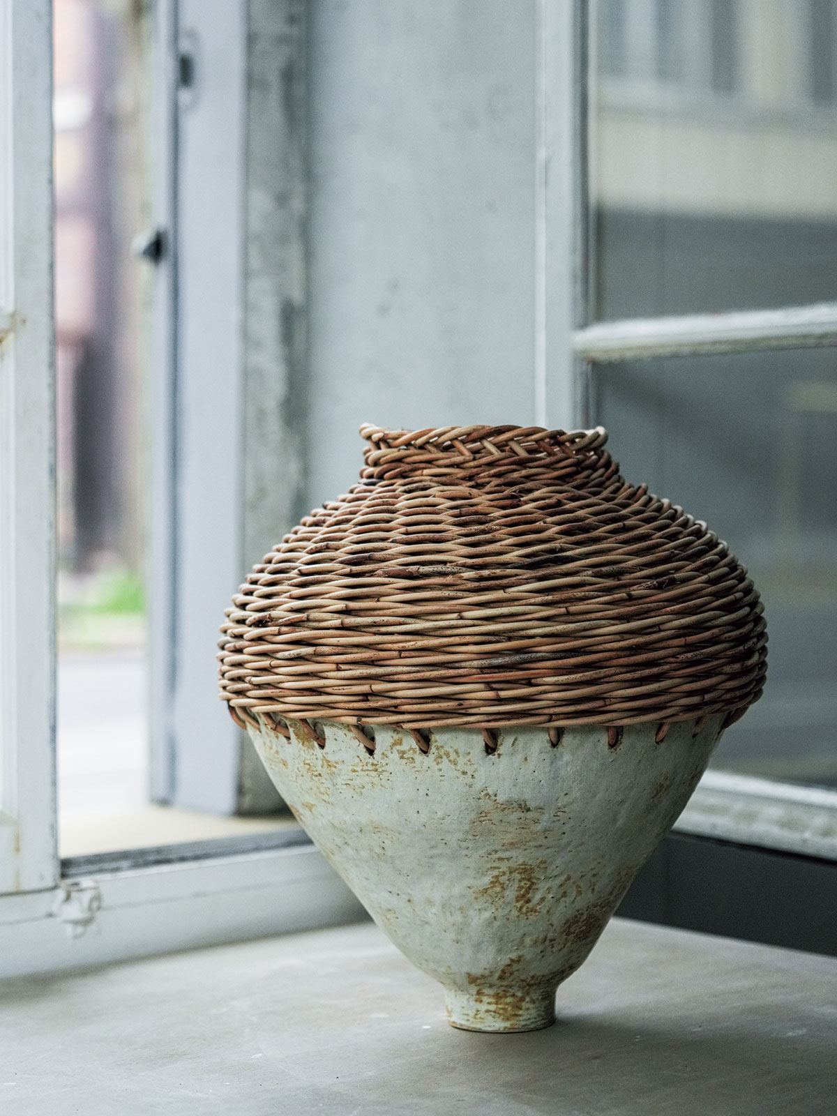 大型の花瓶にはカゴを編み込んで、独特のフォルムを形成。アトリエには窯もあり、すべて自身が制作している。