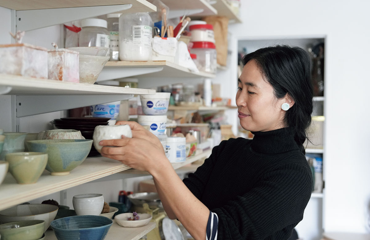 アトリエ内にある作品をチェックする麻美さん。長期バカンスではフランス人の旦那さまと2人の子どもを連れて、奄美大島に行くのが定番になっているとか。